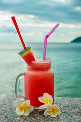 Two fresh fruit cocktails on tropical island with sea view background
