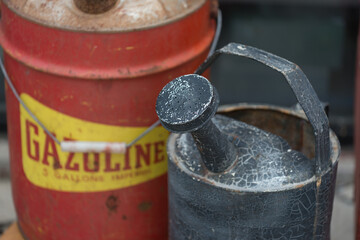 antique metallic watering can and rusty gas can