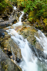 Obraz premium Deception Creek cascading across and over rocks at the falls in the Mount Baker Snoqualmie National Forest in Washington State