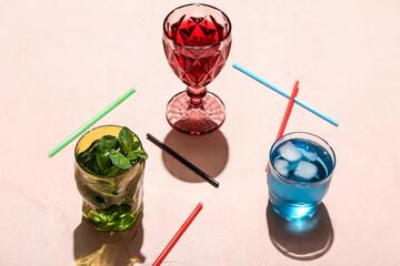 Glasses of fresh cocktails on color background