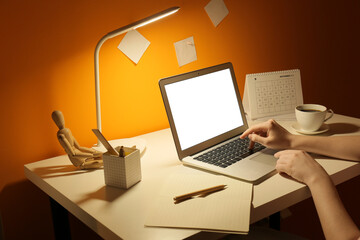 Woman using laptop at home late in evening