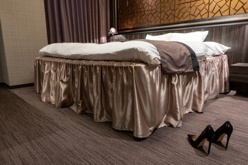 黒いハイヒールとラグジュアリーなベッドルームblack shiny high heels in the luxury bed room	
