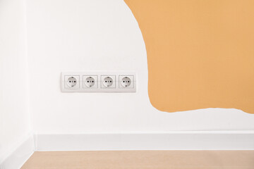 Electric socket with plug on color wall