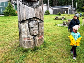 A mother and daughter admiring a totem pole at the beautiful Haida Cultural centre, in Skidegate,...