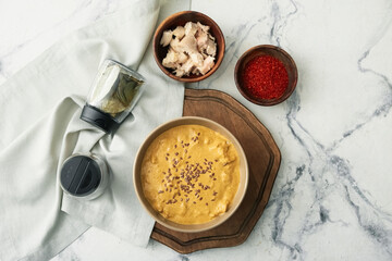 Bowl of tasty chicken curry and ingredients on light background