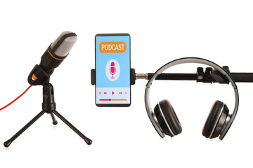 Modern microphone with headphones and mobile phone with podcast playlist on screen against white...