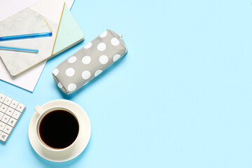 Stylish pencil case, cup of coffee and stationery on color background, closeup