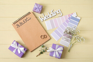 Composition with wedding rings, color samples and notebook with text TO DO LIST on yellow wooden background