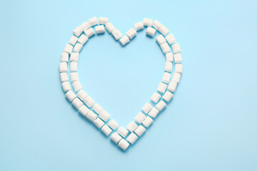 Heart made of tasty marshmallows on color background