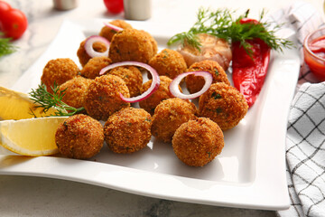 Plate with tasty cod cutlets on light background, closeup