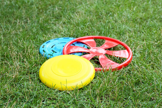 Different frisbee disks on grass outdoors