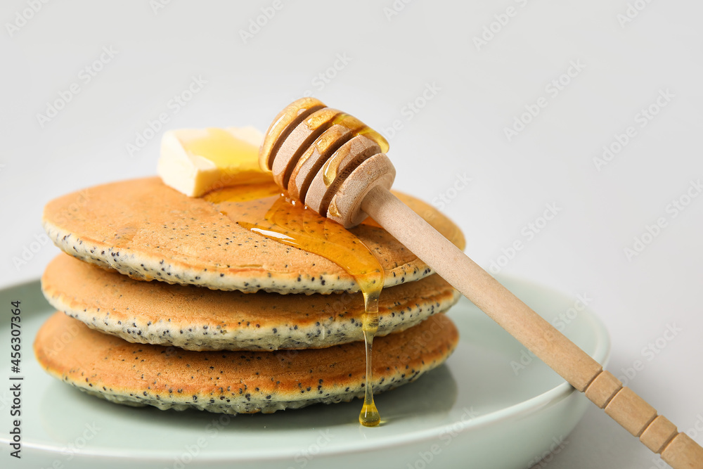 Wall mural plate of tasty pancakes with honey and butter on light background, closeup