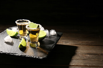 Shots of tasty tequila with lime on table