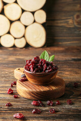 Bowl with tasty dried cranberries on table