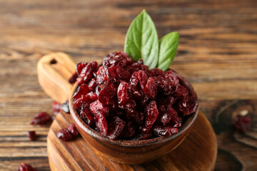 Bowl with tasty dried cranberries on table, closeup