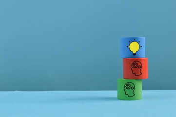 Wooden block with human head and light bulb symbols