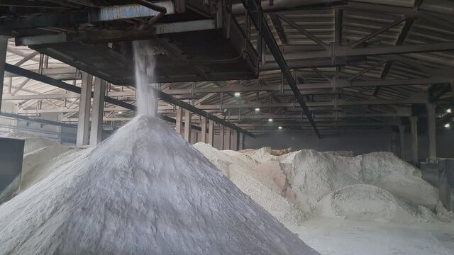 Ammonium sulfate powder pour in a pile inside a warehouse of chemical plant. Mineral organic fertilizers for agriculture industry.