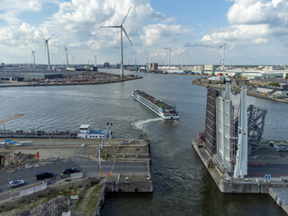Aerial drone photo of a cruise ship by the Siberia brug bridge in the port of Antwerp with windmills of the ports of Antwerp in the background