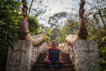 Young woman meditates in a temple in Laos, Asia. 