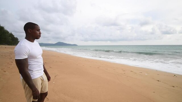 Afro American sports guy looking at sea.