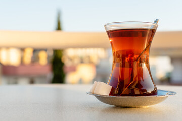 Traditional Turkish tea in a glass glass with a saucer