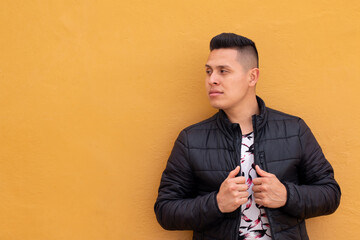 Man against wall with yellow color texture. Serious man with seductive look. Concept of expressions with copy space on single color background.