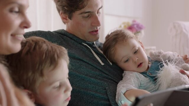 happy family using tablet computer at home mother and father with children watching entertainment playing game on touchscreen device learning having fun together 4k footage 