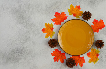 empty yellow ceramic plate, autumn leaves maple, food flat lay, thanksgiving day dish, background with copy space text, holiday mock up