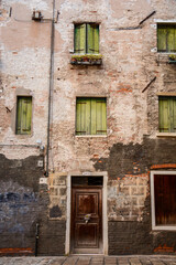 Fototapeta na wymiar Fachadas típicas de Venecia Italia Europa casa edificio con ventanas y puerta antigua pared con textura vieja 