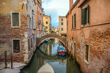 Fototapeta na wymiar Fachadas típicas de Venecia Italia con góndola paseando en el agua por las calles de Venecia en medio de las casas y viviendas