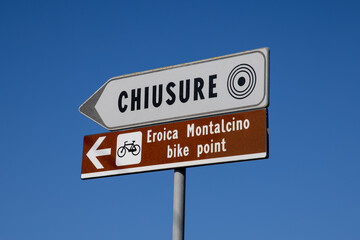 Italy, Tuscany. Chiusure center direction sign and Montalcino bike point. Small village of Chiusure in the province of Siena, unesco word heritage