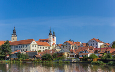 Skyline with castle and old houses reflected in the lake in Telc, Czech Republic