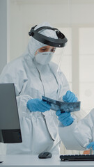 Fototapeta premium Medical stomatology staff working on teeth healthcare for patient at dental clinic, wearing protection suits. Nurse using modern computer at desk while dentist holding x ray for implant