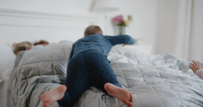 Happy Children Jumping On Bed Waking Up Mother And Father Enjoying Playful Morning With Kids On Weekend Morning At Home 4k Footage