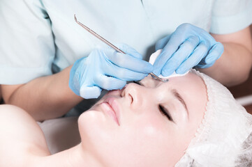 Relaxed young caucasian woman at a beautician appointment. Mechanical face cleansing and peeling. Close-up