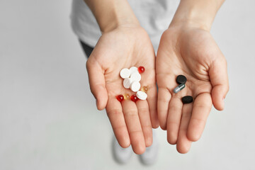 sick woman pills in hand pain reliever light background