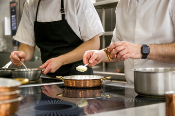 Busy restaurant kitchen. Chef and cooks preparing dishes.