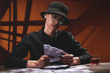 A cool guy in round glasses holds a fan of money