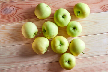 Young organic apples lie on a wooden table
