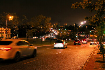 Tráfico nocturno en el barrio de Montecarmelo en Madrid, España. Luces de coche, farolas y...