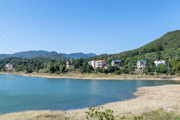 Opposite the lake is the mountain, the sky is blue and the lake water is blue