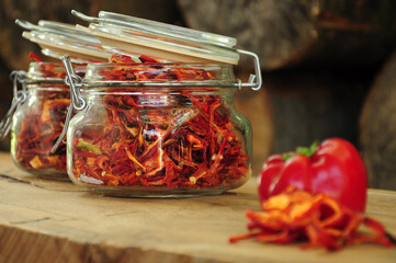Dried peppers in a glass jar on a wooden background. Freeze-dried vegetables. Paprika with fresh paprika. The food is red. Dried spices healthy food. Spices. 