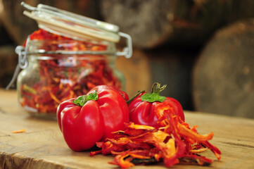 Dried peppers in a glass jar on a wooden background. Freeze-dried vegetables. Paprika with fresh paprika. The food is red. Dried spices healthy food. Spices. 