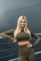 Portrait of a happy beautiful fitness girl with a smile in sportswear in the city