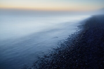 Breathtaking panoramic aerial view of the Baltic sea shore in a fog. Glowing sky, midnight sun,...