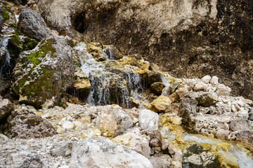 small waterfall of pure water on the dolomites mountains