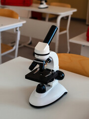 a microscope for a student at a desk in a classroom close-up