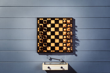 Top view on wooden chess board with figures during the game on gray wooden table background with copy space