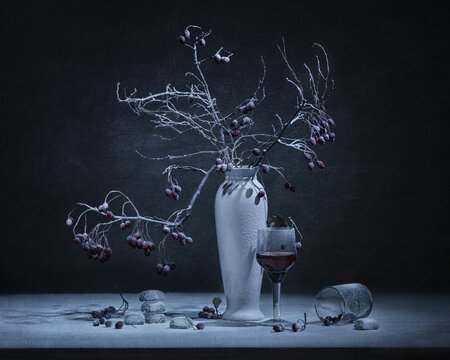 Still life in dark moody style, white vase with tree branches on black background. For wall posters