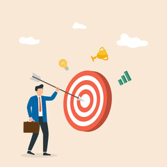 Businessman sticks an arrow at a big target. Goal achievement. Hit the target